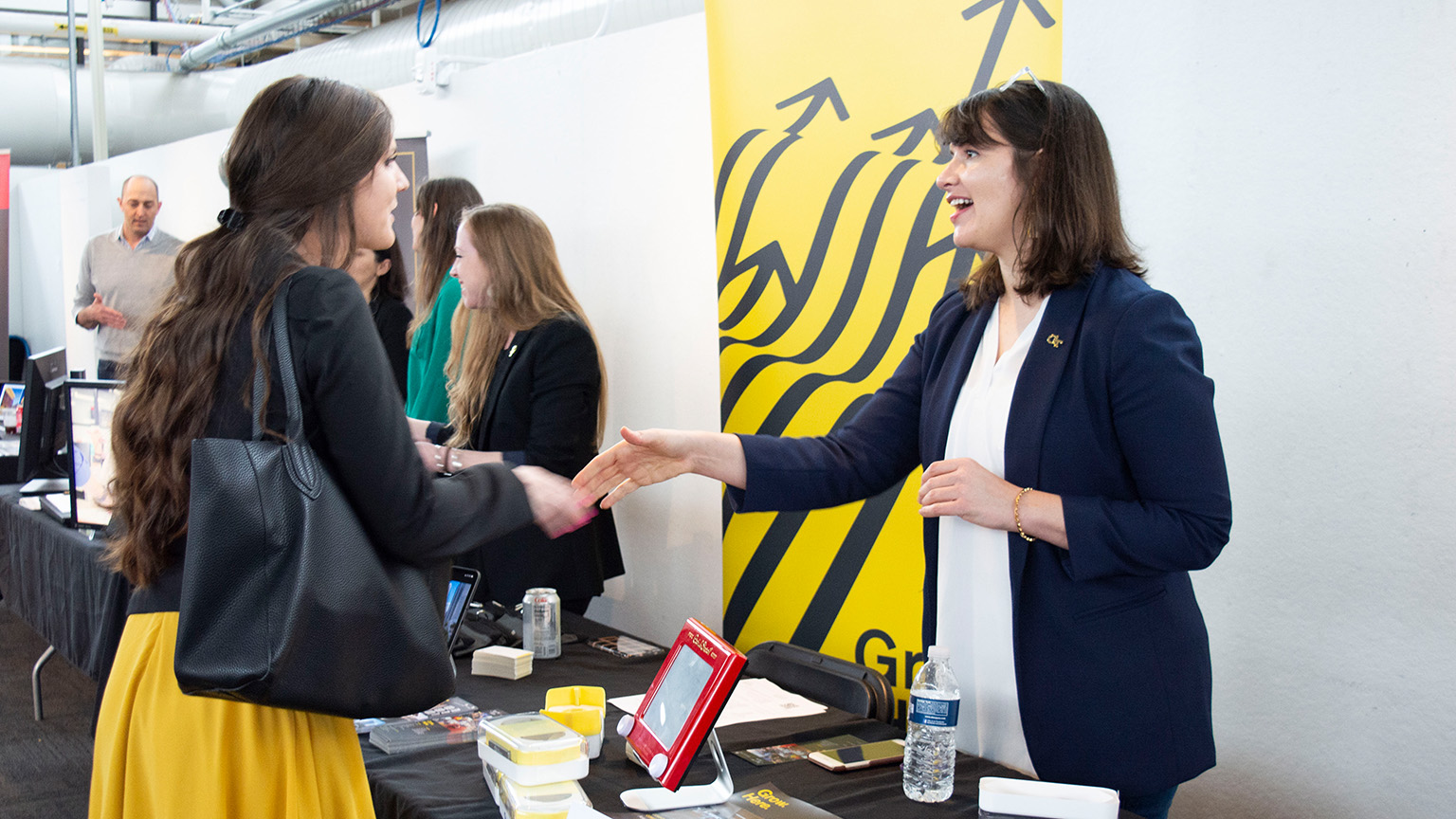A student and an architecture professional shake hands at the 2020 Career Fair in the Architecture West atrium